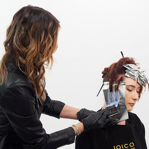 Hairstylist Larisa Love coloring clients hair