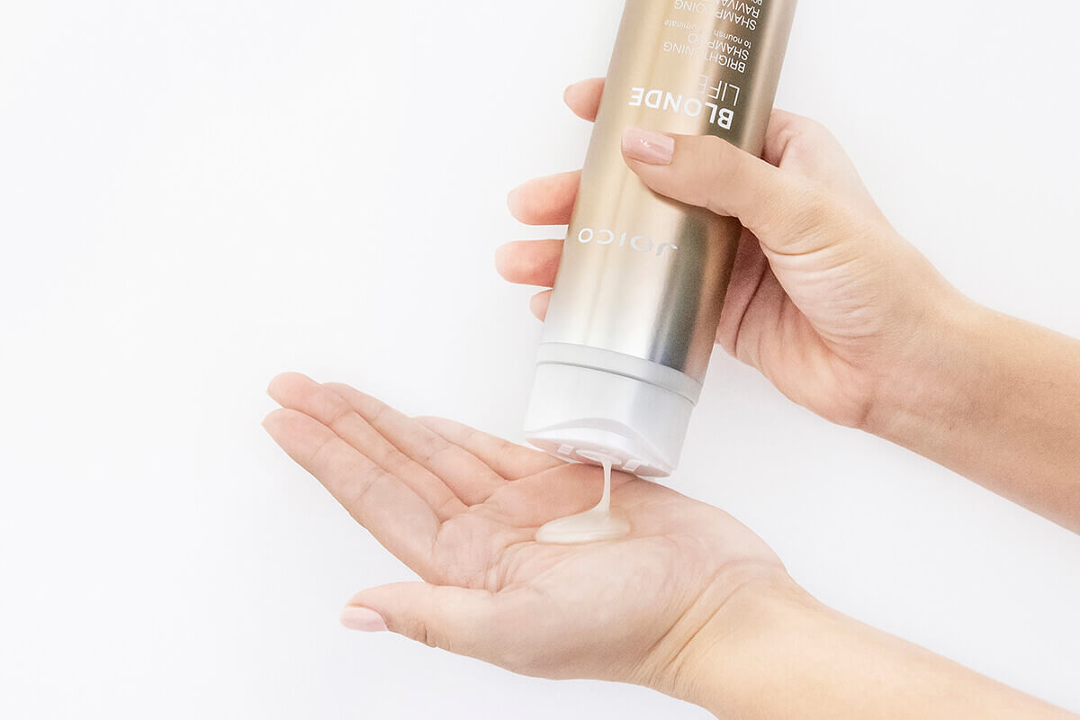 Blond life shampoo bottle squeezing into hand