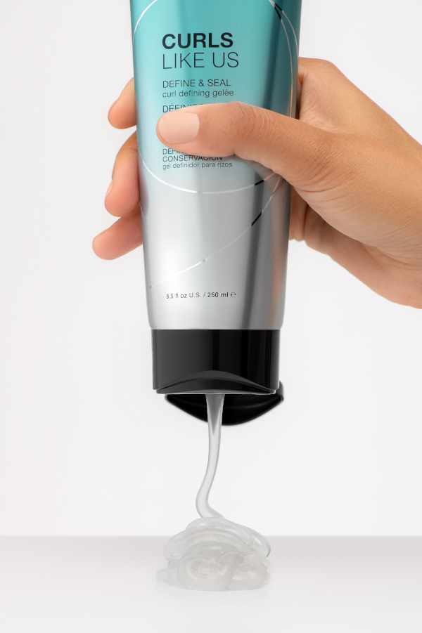 curls like us define and seal gel being poured out